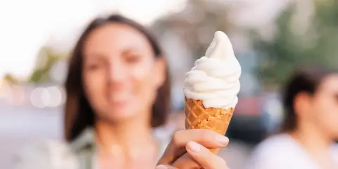 Kobieta trzyma lody na ból gardła. Słodka ochłoda w upalny dzień.