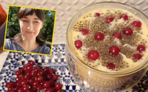 Kobieta uśmiecha się obok deseru z nasionami chia i porzeczkami. Nasiona chia – właściwości odchudzające w pysznej formie.