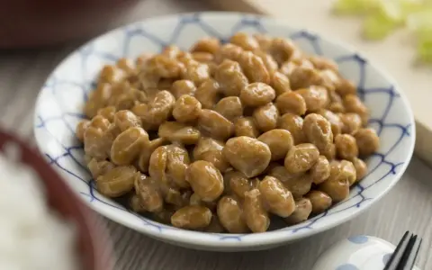 Natto co to? Sfermentowana soja w miseczce z niebieskim wzorem, lekko kleista i błyszcząca.