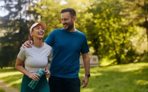 Szczęśliwa para spaceruje po parku. Czy koenzym q10 rano czy wieczorem doda im energii na cały dzień?