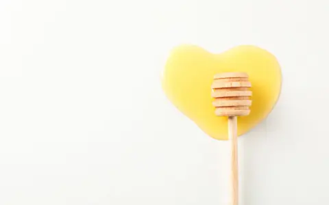 Serce z płynnego miodu i drewniana chochla. Jaki miód na serce? Ten słodki, złocisty płyn.